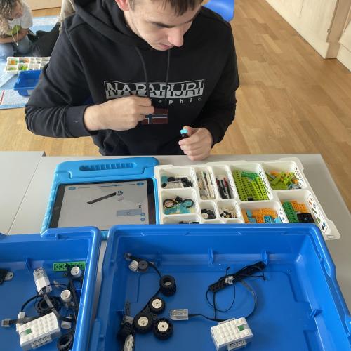 Ein Schüler baut einen Roboter aus Lego